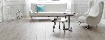 Ein Wohnzimmer mit weißen Möbeln und Holzböden. T&K WOHNSTDIO - Raumausstattung, Bodenbeläge, Vinylboden, Parkett, Gardinen - Saarburger Straße 25, 67071 Ludwigshafen
